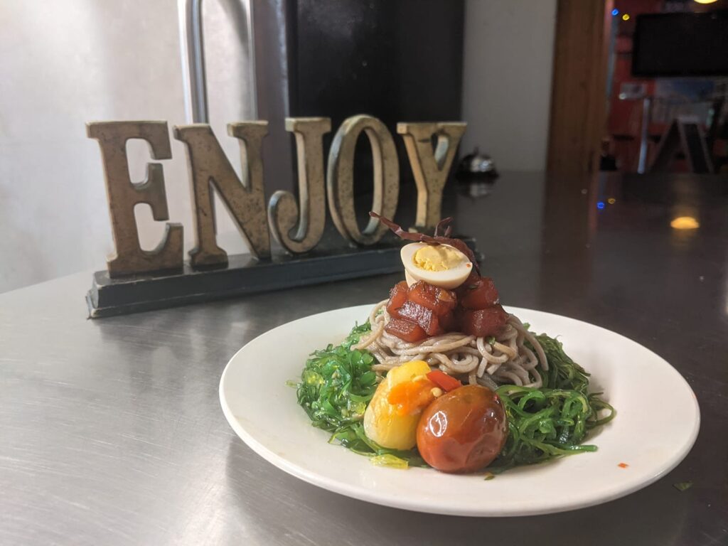 Ahi tuna poke over soba noodles and seaweed salad served with blistered tomatoes and pickled quail egg. Yup! For real.